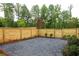 Private backyard features gravel, new wood fence, and lush landscaping perfect for outdoor enjoyment at 11548 Serenbe Ln, Chattahoochee Hills, GA 30268