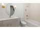 Bright bathroom featuring a sink and vanity, toilet, tub and shower combo with gold fixtures and modern lighting at 11548 Serenbe Ln, Chattahoochee Hills, GA 30268