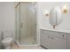 Bright bathroom showcasing a shower, sink and vanity, toilet, gold fixtures, and modern lighting at 11548 Serenbe Ln, Chattahoochee Hills, GA 30268