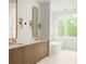 Bright bathroom featuring double vanity, wood cabinets, gold fixtures, mirrors, tub, and scenic outdoor views at 11548 Serenbe Ln, Chattahoochee Hills, GA 30268
