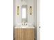 Elegant powder room with a wooden vanity, stylish lighting fixtures, and a modern faucet at 11548 Serenbe Ln, Chattahoochee Hills, GA 30268