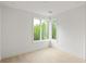Bright bedroom showcasing a corner window and hardwood floors, offering scenic views of the surrounding landscape at 11548 Serenbe Ln, Chattahoochee Hills, GA 30268