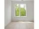 Bright bedroom featuring a window and hardwood floors, offering scenic views of the surrounding landscape at 11548 Serenbe Ln, Chattahoochee Hills, GA 30268