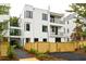 Modern three-story townhome featuring black frame windows, balconies, and a newly constructed wood fence at 11548 Serenbe Ln, Chattahoochee Hills, GA 30268