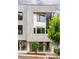 Modern three-story townhouse with clean lines and a light-colored facade, accented by dark window frames and lush greenery at 11548 Serenbe Ln, Chattahoochee Hills, GA 30268