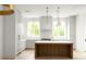 Modern kitchen featuring a wood island, white cabinets, stainless steel appliances, and stylish pendant lighting at 11548 Serenbe Ln, Chattahoochee Hills, GA 30268
