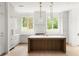 Bright kitchen with white cabinets, a wooden island, and modern lighting fixtures, complemented by stainless steel appliances at 11548 Serenbe Ln, Chattahoochee Hills, GA 30268