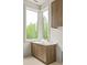 Laundry room showcasing a wooden vanity, quartz countertops, a large window, and views of the outdoors at 11548 Serenbe Ln, Chattahoochee Hills, GA 30268