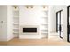 Bright living room showcasing a fireplace with built-in shelving and glass doors leading to the exterior at 11548 Serenbe Ln, Chattahoochee Hills, GA 30268