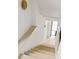 Stairwell featuring light-colored wood steps leading down towards a door to the outside at 11548 Serenbe Ln, Chattahoochee Hills, GA 30268