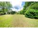 Very large backyard with mature green bushes and a large patch of lawn at 1510 Pecan Plantation Ct, Loganville, GA 30052