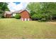 Expansive backyard featuring a brick house exterior, a lush lawn, and privacy trees at 1510 Pecan Plantation Ct, Loganville, GA 30052