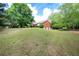 Spacious backyard showcasing a gentle slope and mature trees, offering a serene and private outdoor space at 1510 Pecan Plantation Ct, Loganville, GA 30052