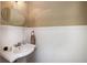 Bright bathroom with a pedestal sink, wainscotting, and a decorative mirror at 1510 Pecan Plantation Ct, Loganville, GA 30052