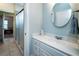 Bright bathroom features a single sink vanity with a white countertop, framed mirror, and a walk-in shower at 1510 Pecan Plantation Ct, Loganville, GA 30052