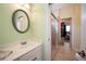 Well-lit bathroom with a single sink vanity, framed mirror, and a glass-enclosed shower at 1510 Pecan Plantation Ct, Loganville, GA 30052