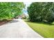 Wide driveway leading to a well-maintained home, complemented by mature trees and lush greenery at 1510 Pecan Plantation Ct, Loganville, GA 30052