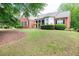 Charming brick home featuring a well-manicured lawn and lush landscaping at 1510 Pecan Plantation Ct, Loganville, GA 30052