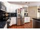 Kitchen with stainless steel refrigerator, granite counters, white cabinetry, and wine rack at 1510 Pecan Plantation Ct, Loganville, GA 30052