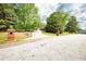 Property entrance with brick pillars, a long driveway, and a view of the home nestled among mature trees at 1510 Pecan Plantation Ct, Loganville, GA 30052
