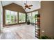 Light-filled sunroom with vaulted ceilings, multiple windows, hardwood floors, and a ceiling fan at 1510 Pecan Plantation Ct, Loganville, GA 30052
