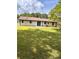 Expansive backyard featuring a well-maintained lawn, mature trees, and a neutral toned patio area at 4074 Green Hawk Trl, Decatur, GA 30035