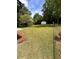Expansive backyard featuring a lush lawn, mature trees, and a storage shed at 4074 Green Hawk Trl, Decatur, GA 30035