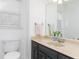 Clean bathroom with dark vanity, beige sink, and toilet next to a window at 4344 White Surrey Nw Dr, Kennesaw, GA 30144