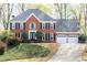 Charming two-story red brick home with a three-car garage and well-maintained landscaping at 4344 White Surrey Nw Dr, Kennesaw, GA 30144