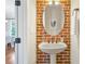 Stylish pedestal sink features exposed brick backsplash and decorative oval mirror at 1199 Huff Nw Rd # 112, Atlanta, GA 30318