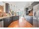 Modern kitchen with dark cabinetry, stainless steel appliances, brick accent wall and hardwood floors at 1199 Huff Nw Rd # 112, Atlanta, GA 30318