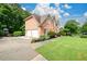 Two-car garage and pristine landscaping highlighting the exterior of this stately brick home at 1430 Hampton Hill Dr, Alpharetta, GA 30022
