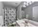 Cozy bathroom featuring a floral shower curtain and a sink with a large mirror at 2695 Ridge Run Trl, Duluth, GA 30097