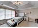 Bright bedroom with a tray ceiling, a ceiling fan, and a bench by the large window at 2695 Ridge Run Trl, Duluth, GA 30097