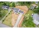 Aerial view of a charming two-story home featuring a long driveway and a well-manicured front lawn at 565 Deer Sw Run, Lilburn, GA 30047