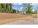 Large backyard featuring newly laid straw, concrete patio and a wooden fence at 565 Deer Sw Run, Lilburn, GA 30047