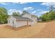 Home exterior with a spacious yard covered in straw, wooden fence, and trees at 565 Deer Sw Run, Lilburn, GA 30047