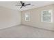 Bright bedroom features neutral walls, plush carpeting, a ceiling fan, and natural light from two windows at 565 Deer Sw Run, Lilburn, GA 30047