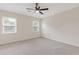Bright bedroom features neutral walls, plush carpeting, a ceiling fan, and natural light from two windows at 565 Deer Sw Run, Lilburn, GA 30047