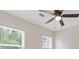 Bright bedroom with a modern ceiling fan and natural light streaming through two large windows at 565 Deer Sw Run, Lilburn, GA 30047