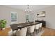 Staged dining room featuring a large table, modern chandelier, and hardwood floors at 565 Deer Sw Run, Lilburn, GA 30047