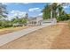 Long driveway leading to a charming two-story home with an attached garage at 565 Deer Sw Run, Lilburn, GA 30047