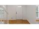 Welcoming entryway with hardwood floors, a white front door, and natural light at 565 Deer Sw Run, Lilburn, GA 30047