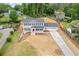 Aerial front view of a two-story home with a red front door, white porch and attached garage at 565 Deer Sw Run, Lilburn, GA 30047