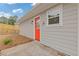 Exterior view of home featuring a bright orange door and manicured landscaping at 565 Deer Sw Run, Lilburn, GA 30047