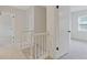 Second floor hallway with white railing and trim, carpet flooring, and natural light at 565 Deer Sw Run, Lilburn, GA 30047