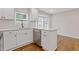 Updated kitchen featuring stainless steel dishwasher, white cabinets, and hardwood floors at 565 Deer Sw Run, Lilburn, GA 30047