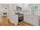 Open kitchen with stainless steel gas range and microwave and hardwood floors at 565 Deer Sw Run, Lilburn, GA 30047