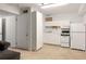 Basement kitchen with white appliances, white cabinets, and neutral walls and carpeting at 922 Barton Woods Ne Rd, Atlanta, GA 30307