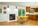 Inviting dining area next to the kitchen area features retro yellow furniture and a brick fireplace at 922 Barton Woods Ne Rd, Atlanta, GA 30307